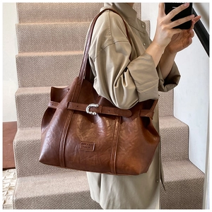 Dettaglio borsa tote vintage in PU marrone con fibbia argentata su una modella