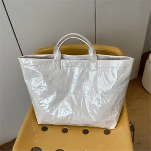 Glossy crinkled cream DuPont paper tote bag with TOTE BAG print on yellow chair