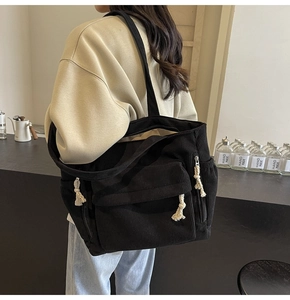 Détail du sac fourre-tout en velours côtelé noir avec fermetures en corde de coton blanc