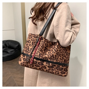 Détail d'un cabas en velours léopard avec lanières en cuir porté par un mannequin