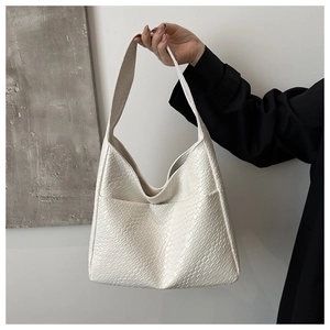 Detail of the white PU leather tote bag featuring a premium woven texture and wide shoulder strap