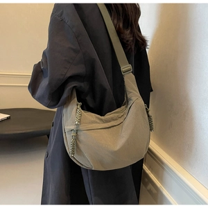Detail view of olive green crescent dumpling bag with decorative rope knot zipper