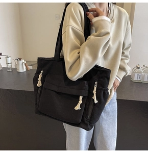 Détail du sac bandoulière en velours côtelé noir avec poche à rabat et cordons de serrage