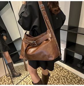 Detail view of the side profile and adjustable shoulder strap of the brown PU leather hobo bag