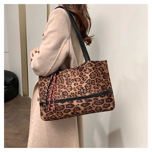 Détail du sac cabas en velours léopard avec anses noires et pompon tricolore