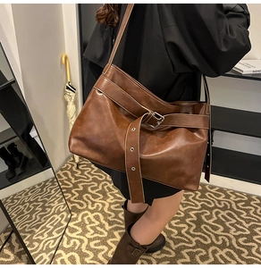 Detail view of the deep brown vintage PU tote bag featuring a polished buckle strap