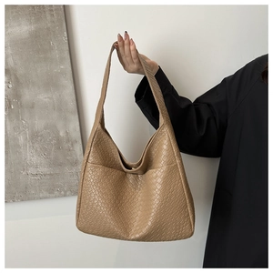 Detail of khaki woven texture hobo bag showing golden magnetic buckle and wide strap