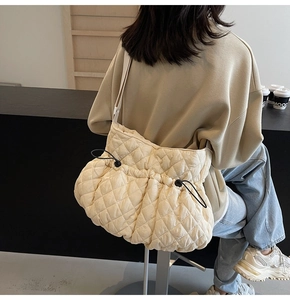 Detail of quilted shoulder bag with drawstring closure and comfortable wide strap