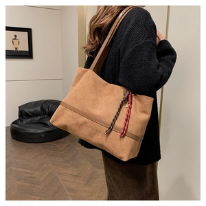 Détail du sac cabas en velours marron avec corde tressée décorative et accents en cuir