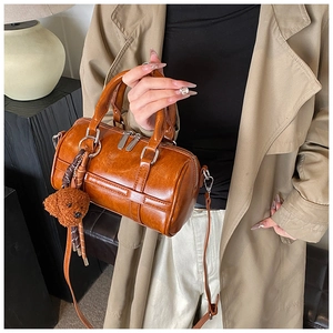 Polished brown PU leather Boston bag detail with cute bear charm and silver hardware