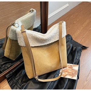 Fashionable suede shoulder bag with white faux shearling trim and stylish leather strap
