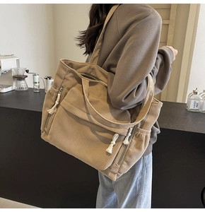 Détail du sac fourre-tout en velours côtelé kaki montrant la capacité latérale