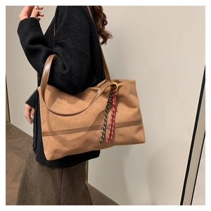 Vue détaillée du sac cabas en daim marron avec bandoulière et cordon tressé décoratif