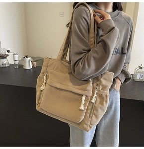 Détail du grand sac cabas en velours côtelé kaki avec poche à rabat et texture robuste