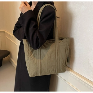 Detail view of khaki nylon tote bag with reinforced straps and smooth zipper buckle