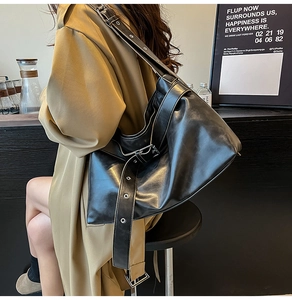 Detail view of high-quality black PU leather shoulder bag with stylish metal eyelet strap