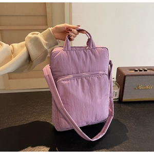 Detail der lila gesteppten Nylon-Schultertasche mit Reißverschlusstasche und Griffen