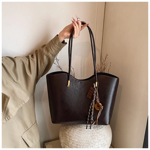 Détail du grand sac cabas en similicuir marron foncé avec pendentifs rétro dorés