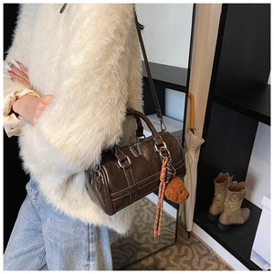 Brown cylinder Boston bag in synthetic leather featuring a cute plush bear charm detail