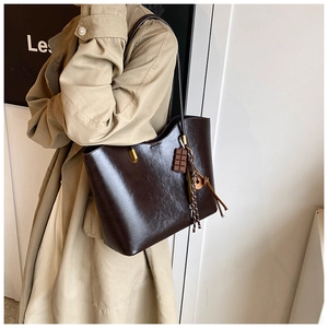 Détail d'un grand sac cabas en cuir PU marron foncé avec charm chocolat et boucles dorées