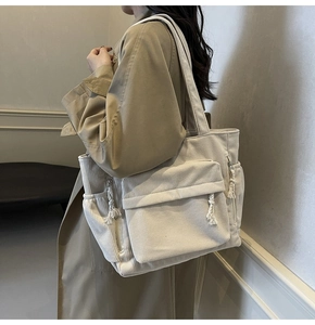 Vue détaillée du sac cabas en velours côtelé blanc cassé montrant la poche latérale