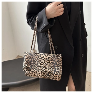 Detail of leopard print shoulder bag with gold chain strap on black blazer outfit