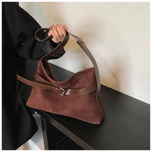 Vue détaillée de la texture du daim marron foncé et de la sangle en cuir avec boucle