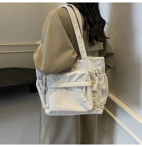 Vue détaillée du sac cabas en velours côtelé crème avec grande capacité et poches latérales