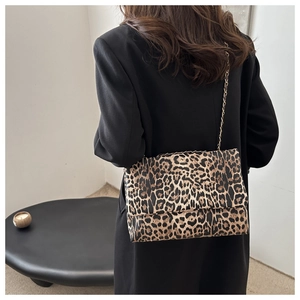 Close-up of leopard print shoulder bag with a thin metal chain strap on model back