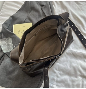Macro view of the spacious dark brown tote bag interior with inner zipper pocket