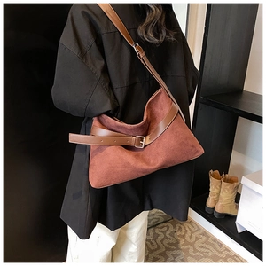 Détail du sac cabas en daim marron avec lanières en cuir et boucle argentée sur modèle