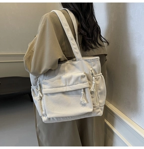 Détail du sac fourre-tout en velours côtelé montrant les poches latérales et la fermeture
