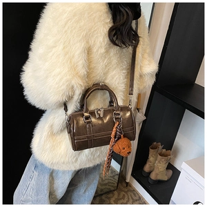 Detail of brown PU leather Boston bag with silk scarf and plush puppy charm