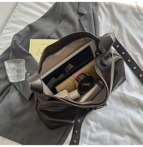 Detail of spacious dark brown PU leather crossbody bag showing large internal capacity
