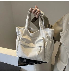 Détail du sac fourre-tout en velours côtelé blanc cassé avec texture et poche frontale