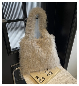 Detailed view of plush faux fur tote bag in light beige on elegant marble surface
