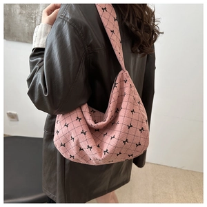 Dettaglio della borsa hobo in velluto a coste rosa con fiocco nero e motivo a rombi