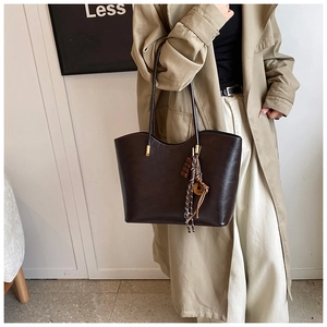 Détail du grand sac cabas en similicuir marron avec boucles dorées et breloque en bois