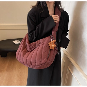 Quilted puffy shoulder bag in burgundy with plush bear charm and wide strap detail