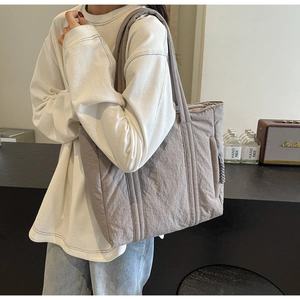 Detail of light purple quilted tote bag showing cloud-like texture and wide shoulder strap