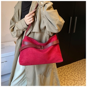 Détail du sac cabas en daim rouge avec sangle à boucle en cuir et anneau en métal