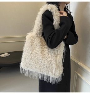 Detail of light beige faux fur shoulder bag with soft long plush texture on black coat