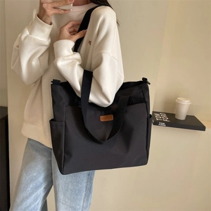 Black large-capacity canvas tote bag with dual straps for daily commuting and student use