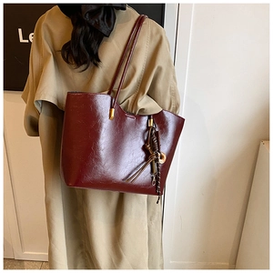 Détail du grand sac cabas en similicuir bordeaux avec finition brillante et dorures