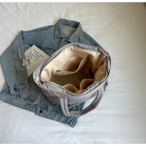 Top view of spacious grey quilted tote bag showing internal compartments and beige lining