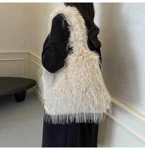 Detail of the soft faux fur texture on a cream plush tote bag worn over the shoulder