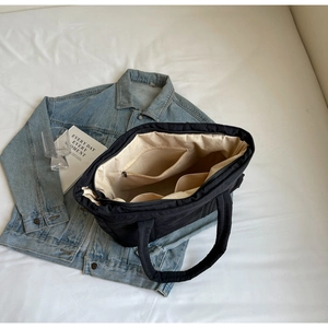 Top view of large black quilted tote bag showing interior lining and functional pockets