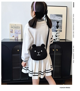Detail showing the plush black bear crossbody bag in a minimalist home decor setting
