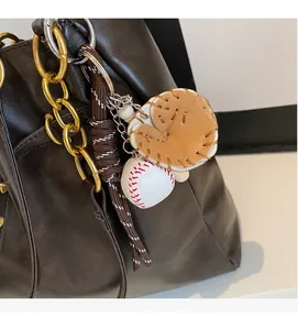 Detailed close-up of a stylish baseball glove and ball pendant charm with gold chain