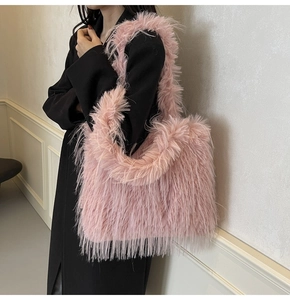 Close-up of soft pink faux fur texture on a stylish tote bag worn with a black coat